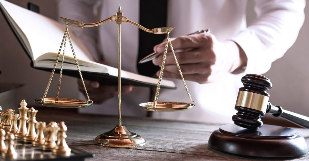 Judge gavel on wood table while looking at book